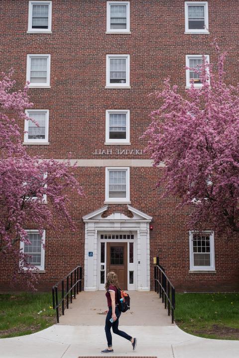 Student walking past Devine Hall