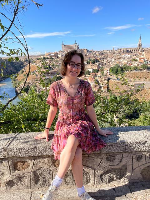 Student sitting on wall, overlooking city