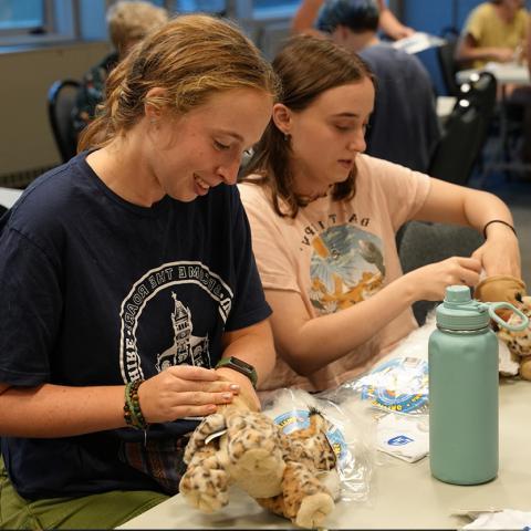 two girls making a stuffed creature 